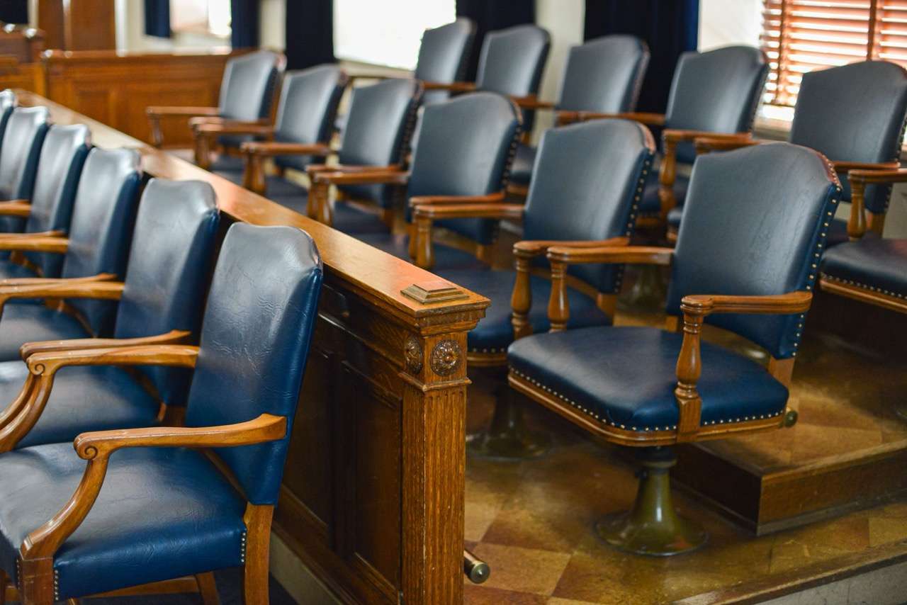 Empty jury seats in a courtroom setting.