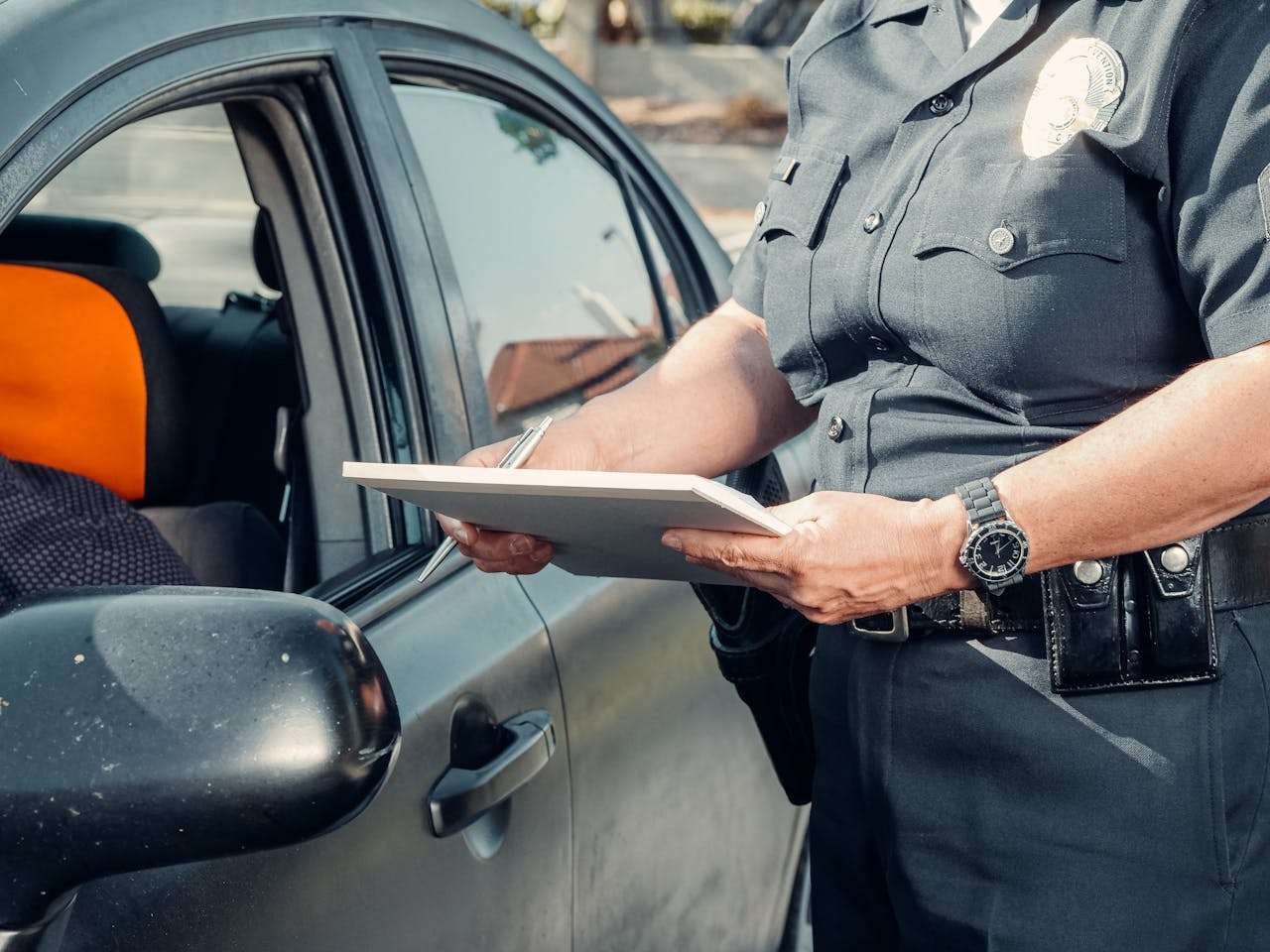 Police officer writing traffic ticket.