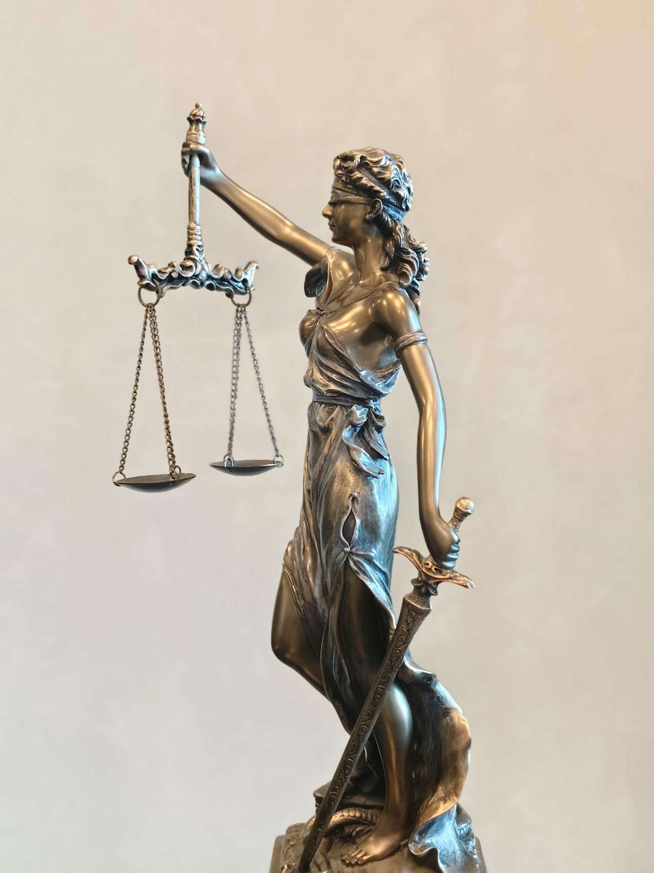 Bronze statue of Lady Justice holding scales.